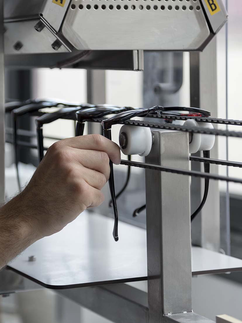 Dies ist ein industrielles Hängebandsystem, das für die Herstellung oder Organisation von Brillen verwendet wird.
