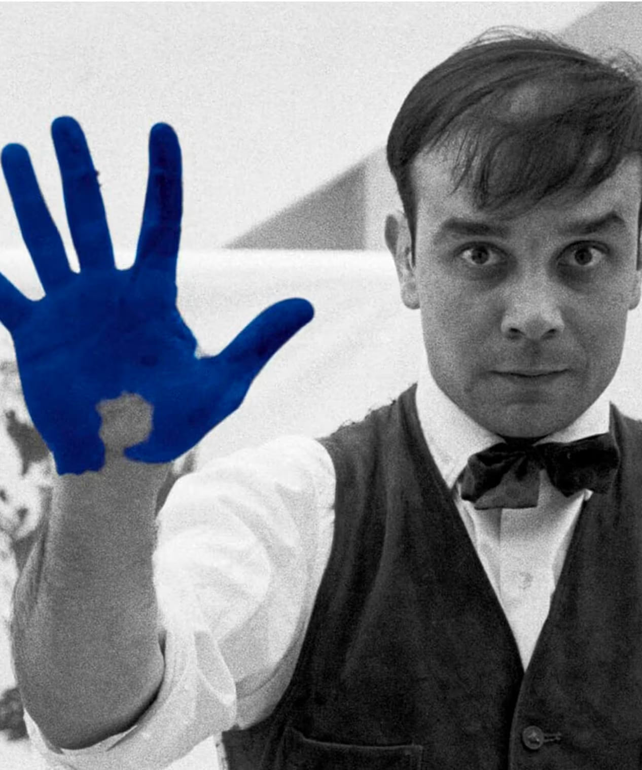Man in formal attire with a blue handprint overlay